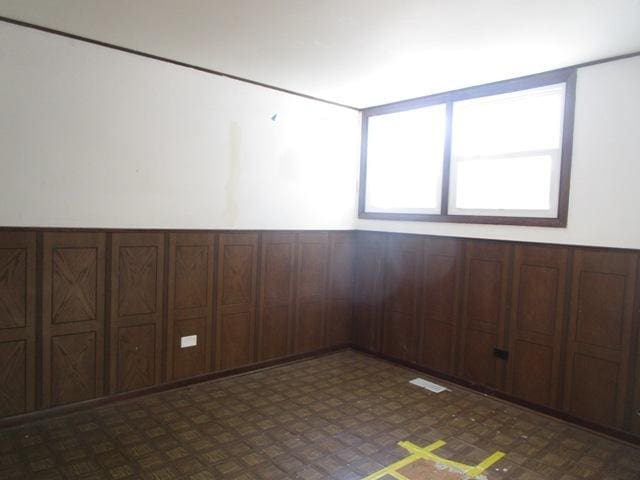 unfurnished room with wooden walls