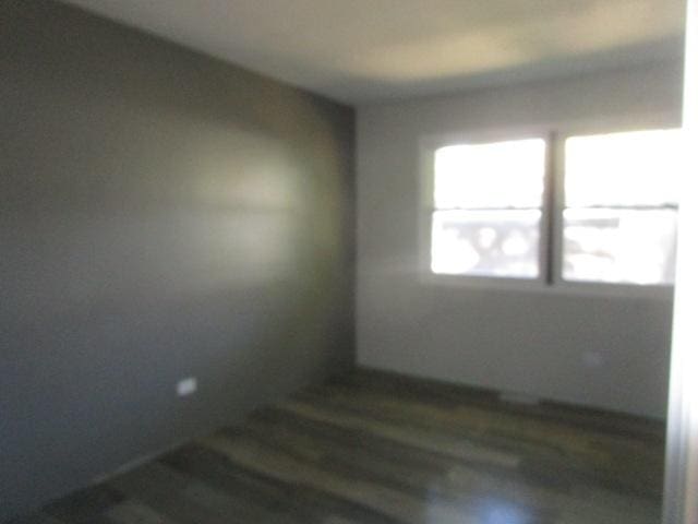 empty room with dark hardwood / wood-style flooring