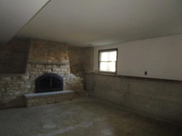 unfurnished living room with a stone fireplace