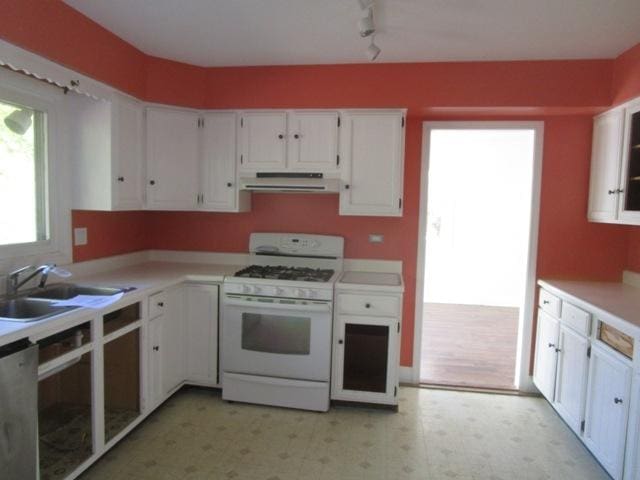 kitchen with white cabinets, white appliances, track lighting, and sink