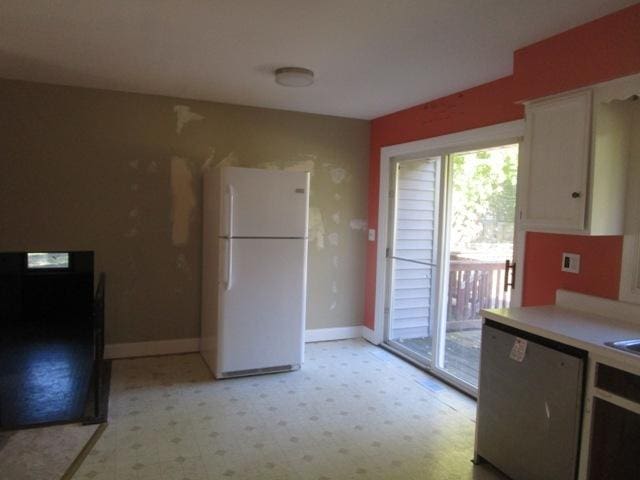 kitchen featuring dishwasher, white refrigerator, and white cabinetry