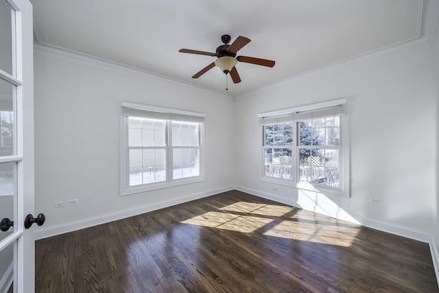 spare room featuring baseboards, ornamental molding, and dark wood finished floors