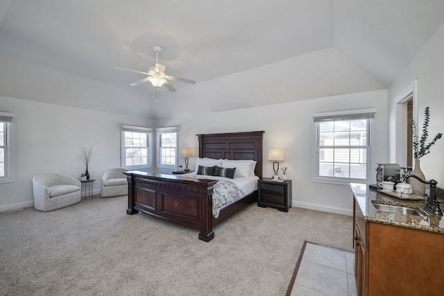 bedroom with a sink, baseboards, lofted ceiling, and light colored carpet