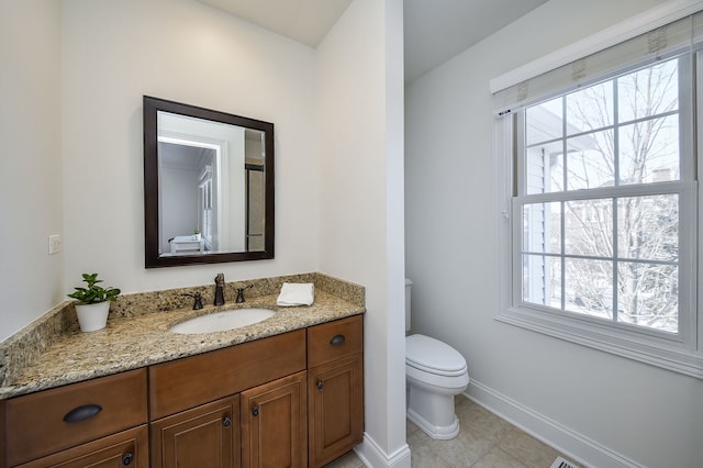 bathroom featuring baseboards, toilet, vanity, and tile patterned flooring