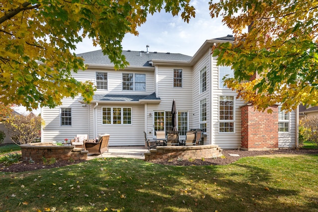 back of property with a lawn and a patio