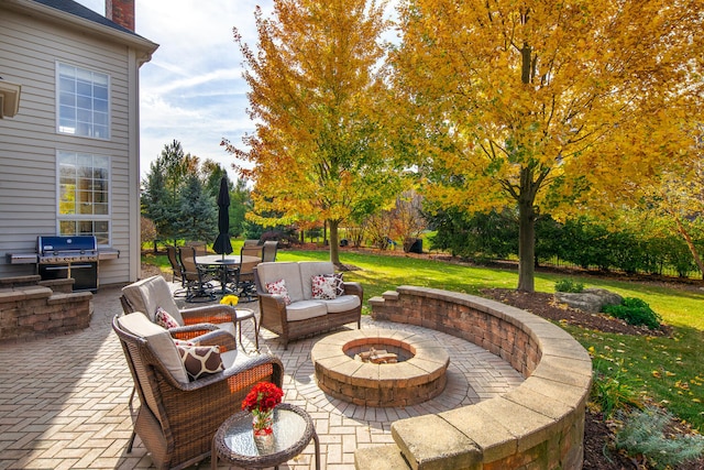 view of patio with outdoor dining area, an outdoor living space with a fire pit, and grilling area