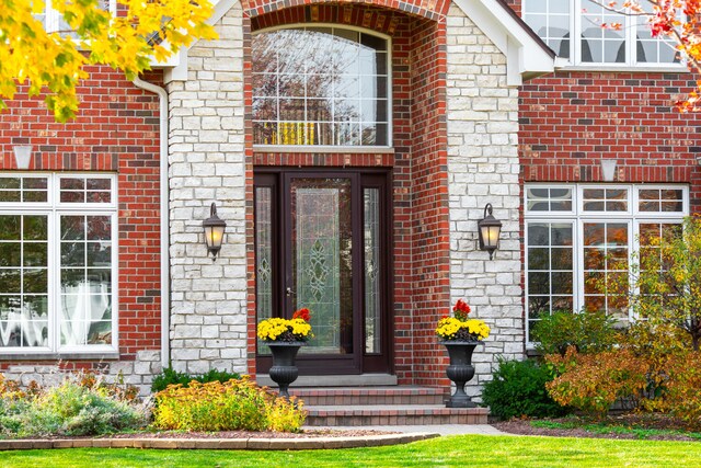 entrance to property featuring brick siding