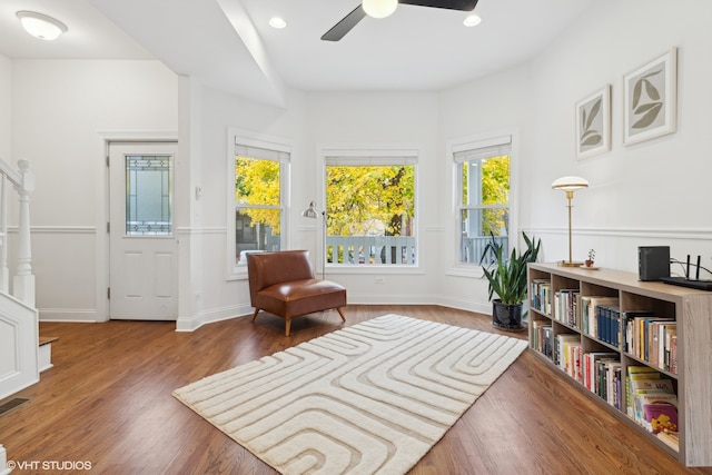 living area with plenty of natural light, ceiling fan, and dark wood-type flooring