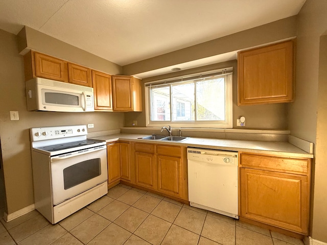 kitchen with light tile patterned flooring, white appliances, and sink