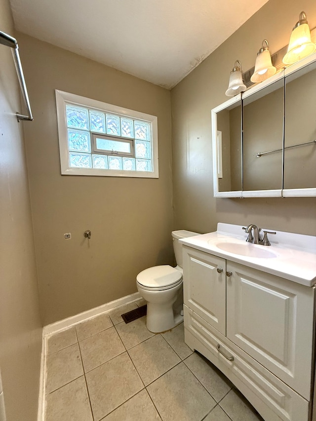 bathroom with tile patterned flooring, vanity, and toilet