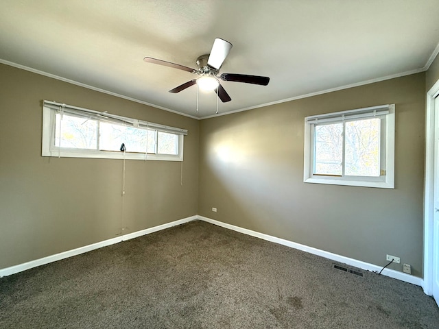 unfurnished room featuring dark colored carpet, ceiling fan, and crown molding