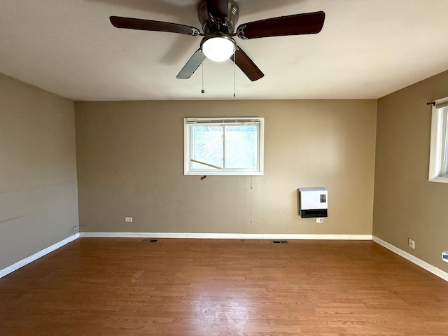 spare room featuring ceiling fan, light hardwood / wood-style floors, and heating unit