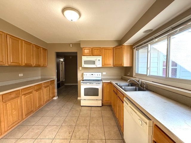 kitchen with sink, light tile patterned floors, and white appliances