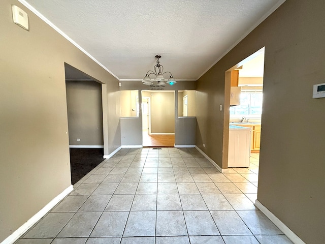 unfurnished dining area featuring a chandelier, light tile patterned floors, a textured ceiling, and crown molding