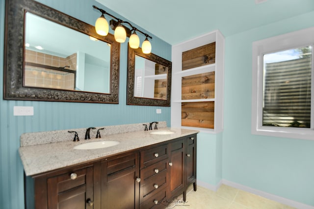 bathroom with tile patterned flooring, vanity, and a shower