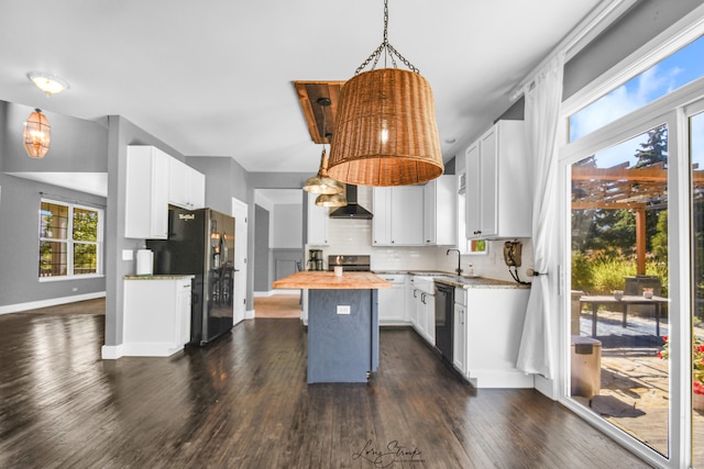 kitchen featuring wooden counters, a center island, white cabinets, black appliances, and backsplash