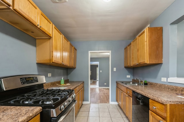 kitchen with sink, stainless steel range with gas cooktop, black dishwasher, and light tile patterned floors