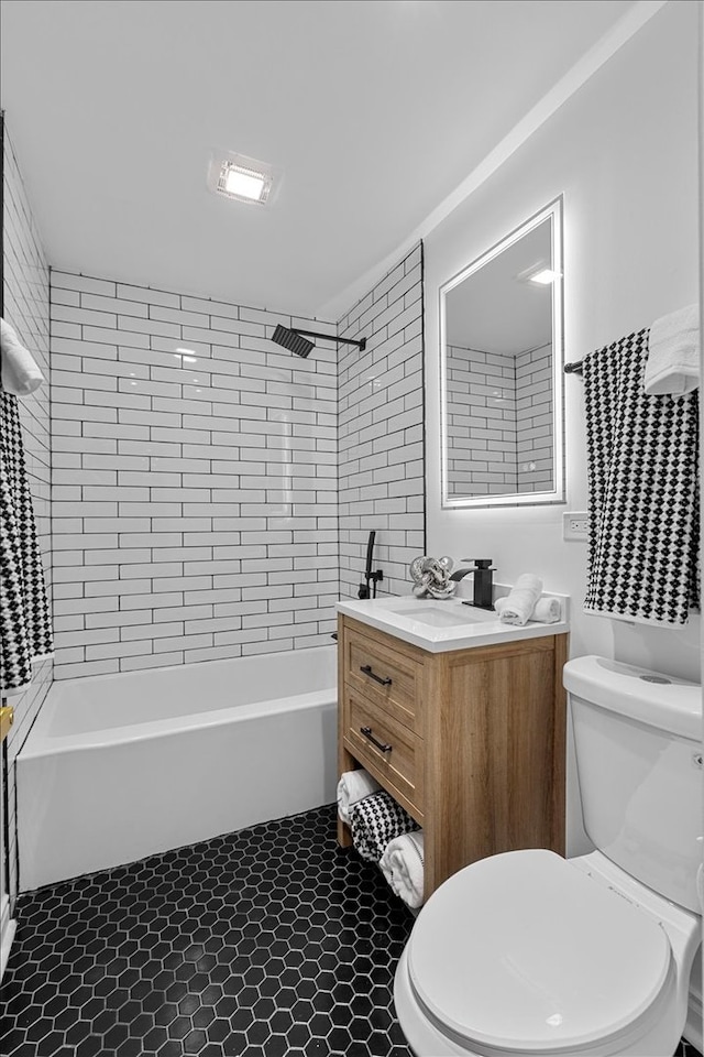 full bathroom featuring tile patterned floors, vanity, tiled shower / bath combo, and toilet