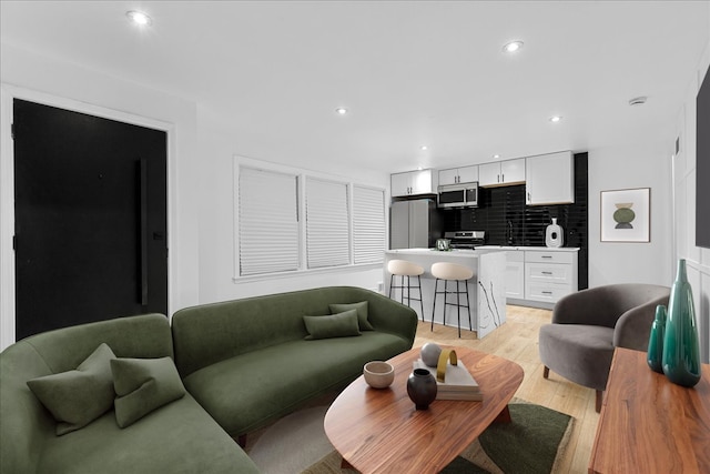 living room featuring sink and light hardwood / wood-style floors