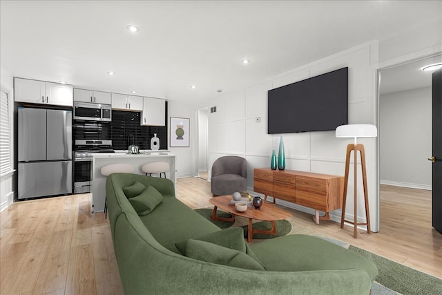 living room with light hardwood / wood-style flooring and sink