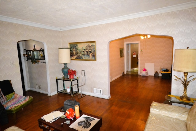 living room with an inviting chandelier, a textured ceiling, dark hardwood / wood-style floors, and crown molding