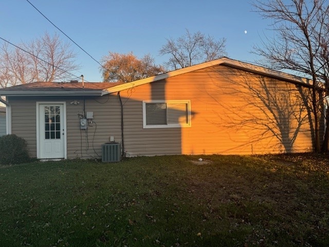 back of house featuring a lawn and cooling unit