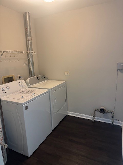 laundry area with dark wood-type flooring and washer and dryer