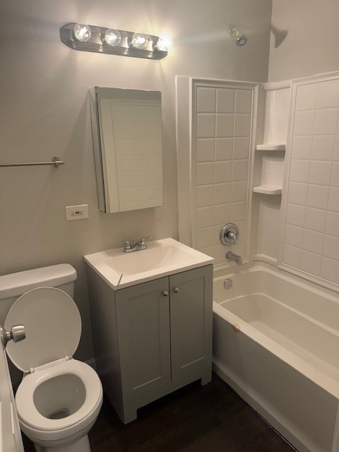 full bathroom featuring tiled shower / bath, hardwood / wood-style flooring, toilet, and vanity