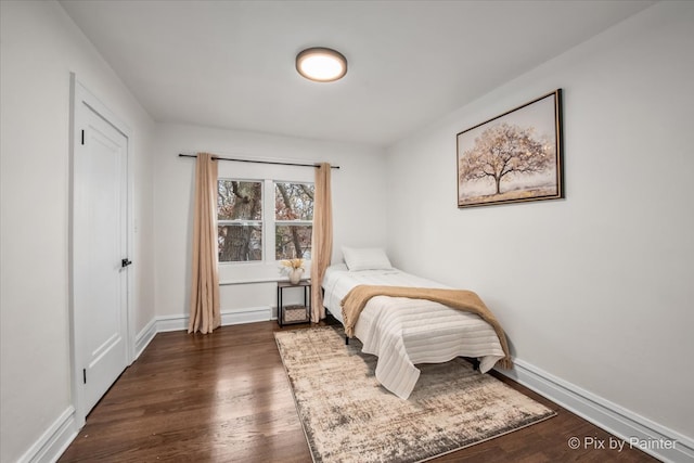 bedroom with dark hardwood / wood-style flooring