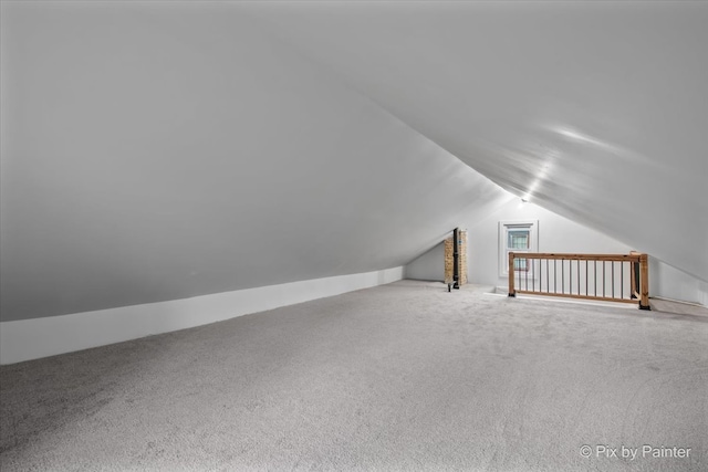 additional living space featuring carpet floors and vaulted ceiling