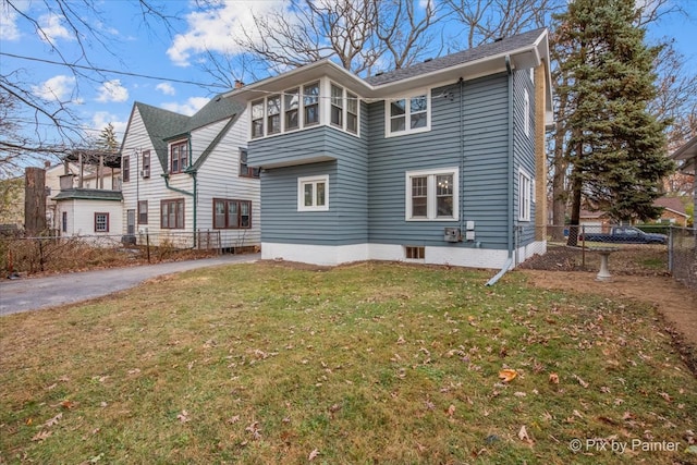 rear view of property with a lawn