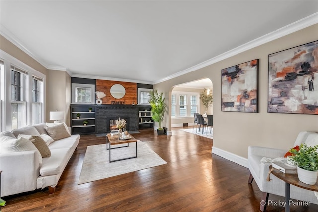 living room with a fireplace, dark hardwood / wood-style flooring, and ornamental molding