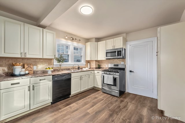 kitchen with sink, dark hardwood / wood-style floors, appliances with stainless steel finishes, tasteful backsplash, and white cabinetry