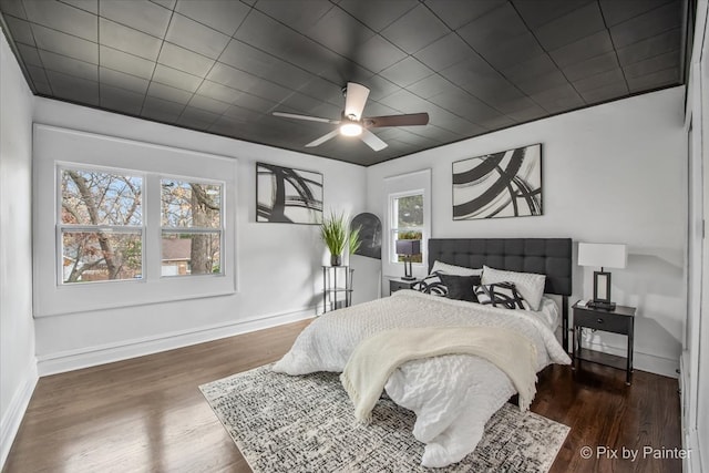 bedroom with dark hardwood / wood-style flooring and ceiling fan