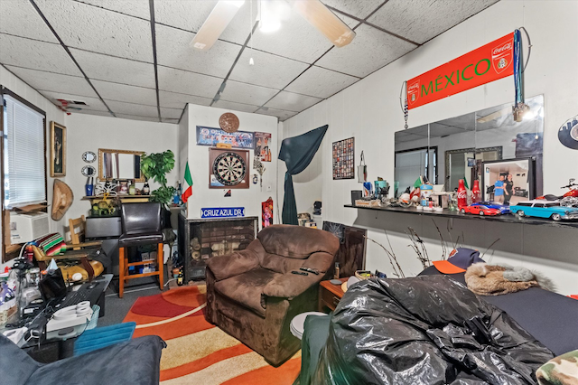 carpeted living room with a fireplace, ceiling fan, and a paneled ceiling