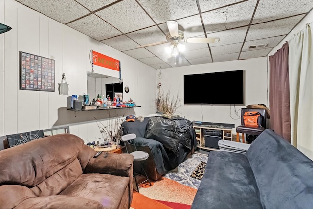 living room with ceiling fan and a drop ceiling