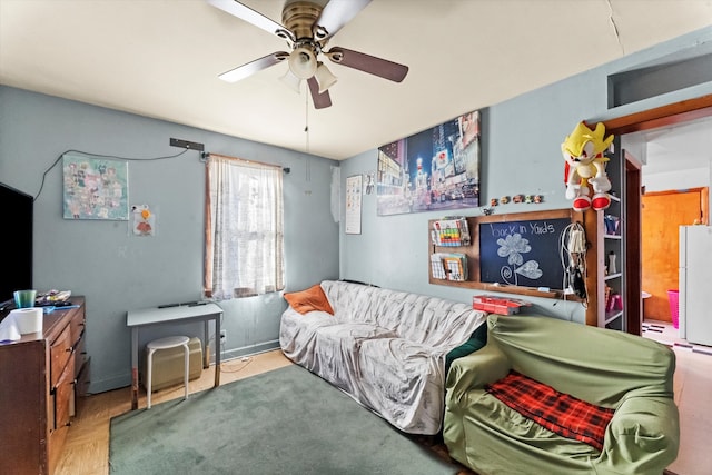 bedroom with white fridge, ceiling fan, and ensuite bath