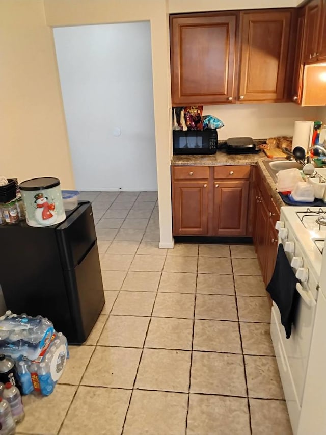 kitchen with light tile patterned floors and black appliances