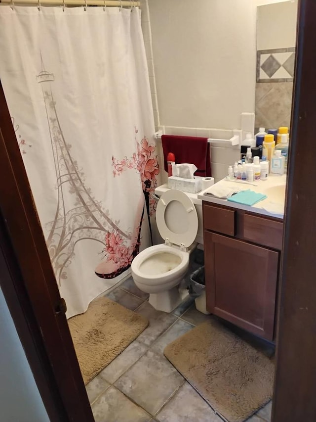 bathroom with vanity, toilet, tile patterned floors, and a shower with shower curtain