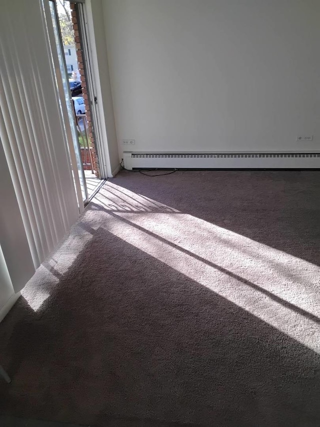 carpeted empty room with a healthy amount of sunlight and a baseboard radiator