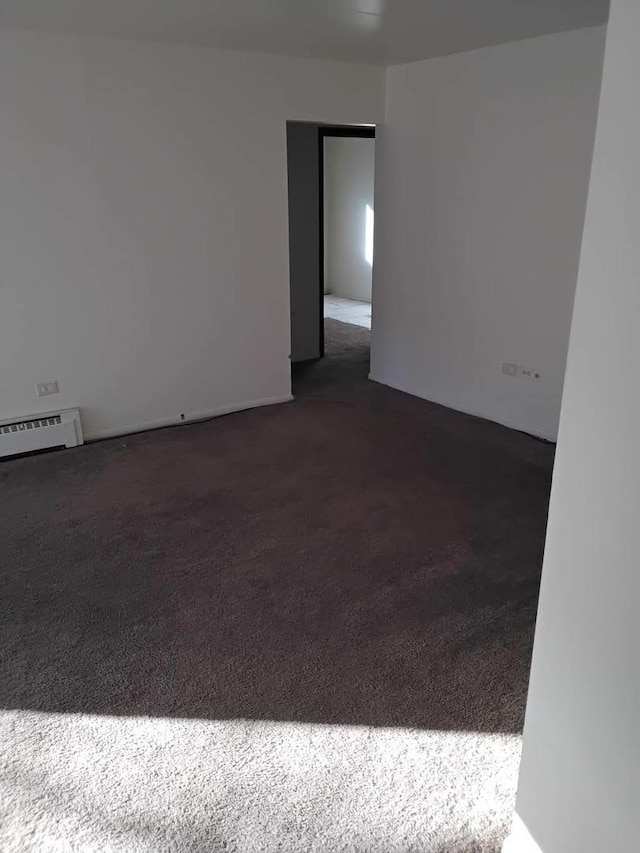 carpeted empty room with baseboard heating