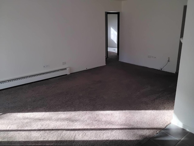 carpeted empty room featuring a baseboard radiator