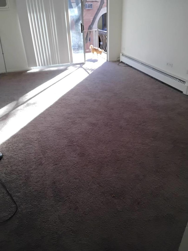 unfurnished room featuring a baseboard radiator and carpet floors