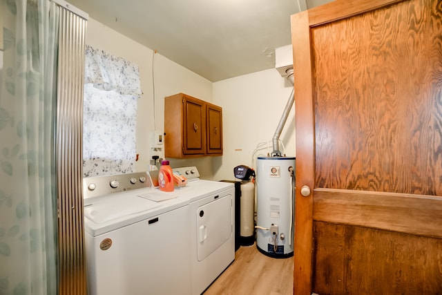 washroom featuring cabinets, independent washer and dryer, gas water heater, and light hardwood / wood-style floors