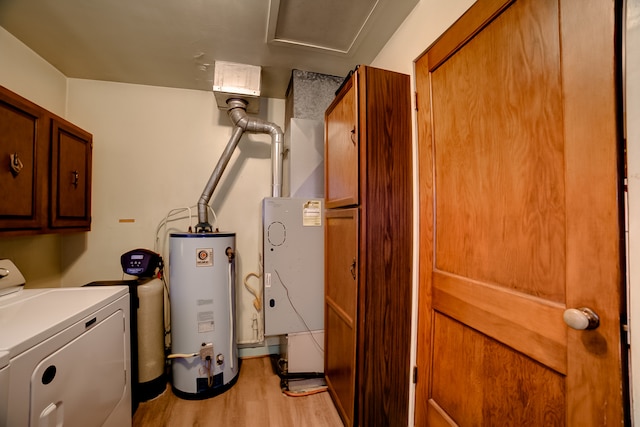 clothes washing area with cabinets, washer / dryer, light hardwood / wood-style flooring, and water heater