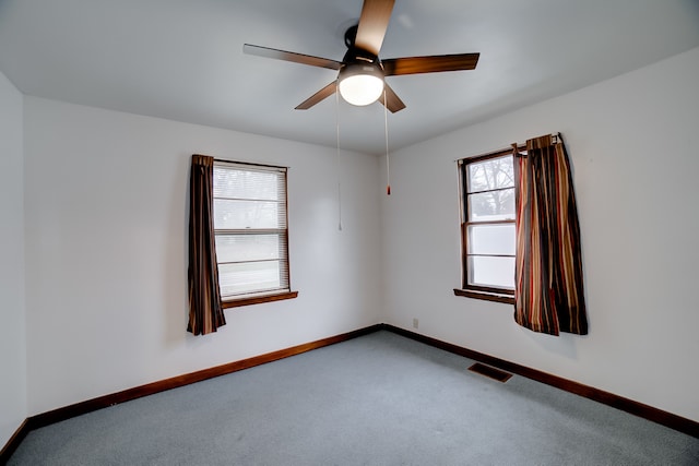 carpeted empty room featuring plenty of natural light and ceiling fan