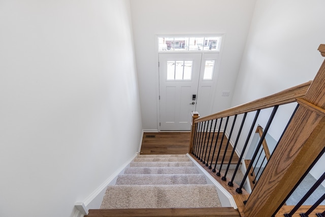 stairs featuring hardwood / wood-style floors