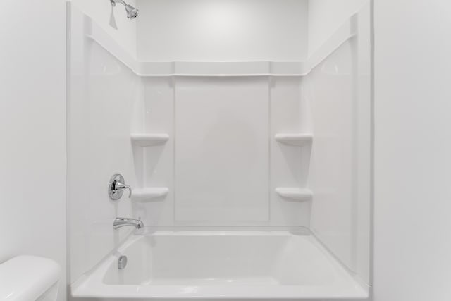 bathroom with washtub / shower combination and toilet