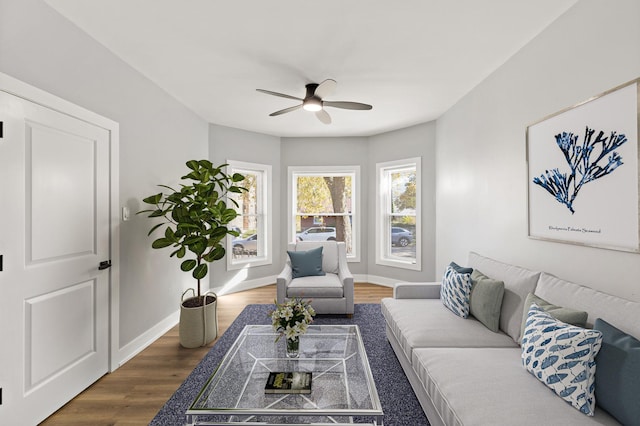 living room featuring dark wood-type flooring and ceiling fan