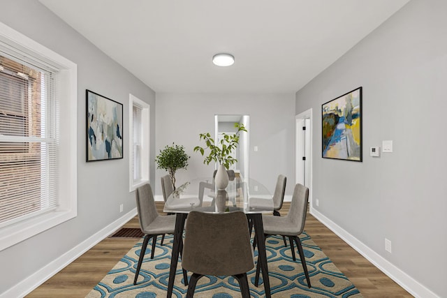 dining space with dark hardwood / wood-style flooring